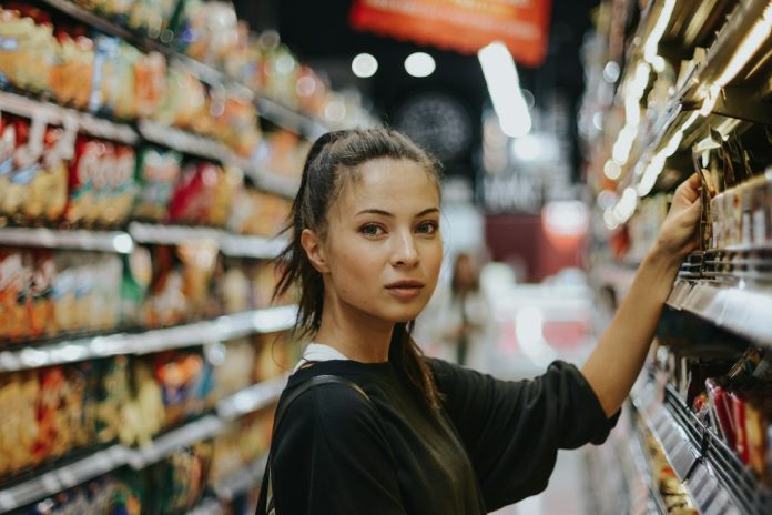 Shopper comparing packaged foods while reading nutrition information