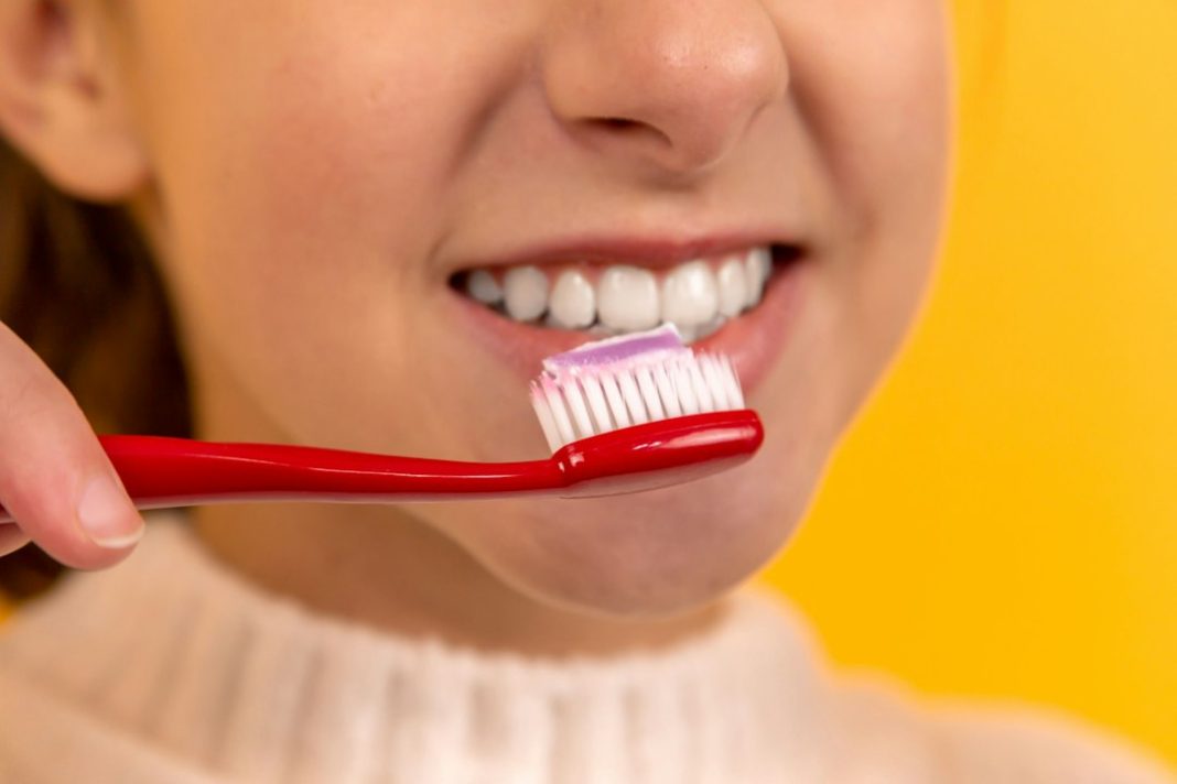 Person brushing their teeth as part of a daily oral health routine