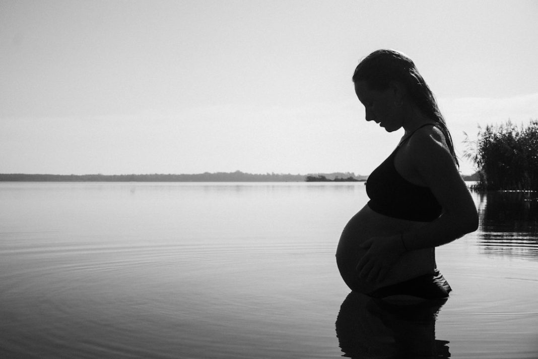 Pregnant woman cooling in water during warm weather