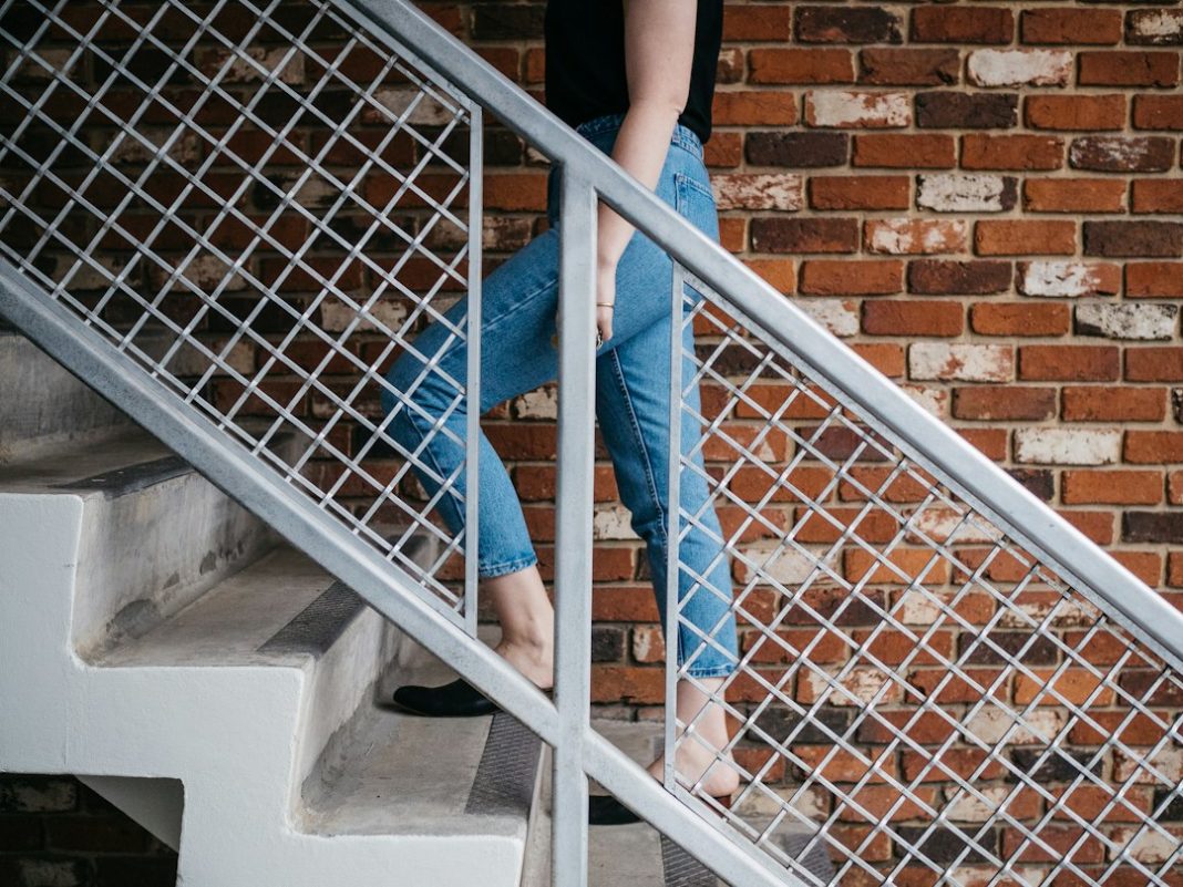 Older adult using a handrail on stairs at home