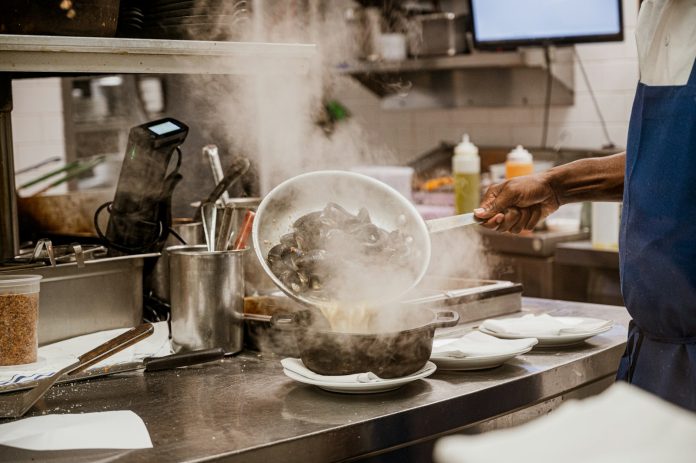 Cook checking food temperature during preparation