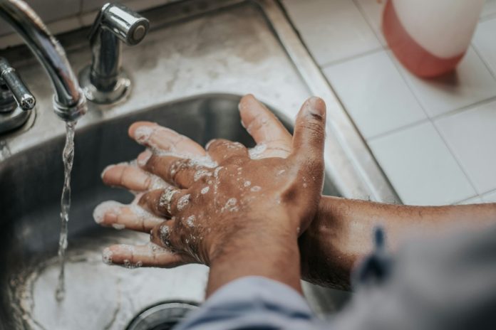 Hands being washed with soap under running water