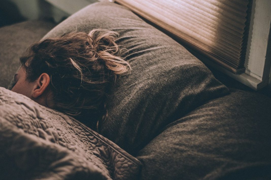 Person resting in bed during a healthy sleep routine