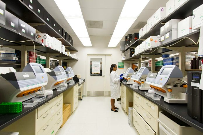 Laboratory technician working with genomic sequencing equipment — research context for losartan and brown fat