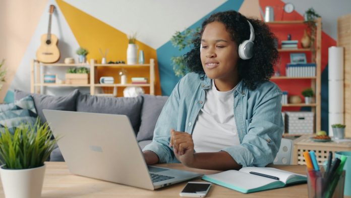 Person wearing headphones indoors, illustrating safer listening habits. Photo by Vitaly Gariev on Unsplash.