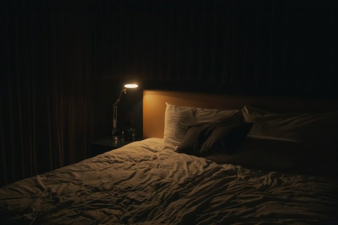 Quiet bedroom with a warm bedside lamp