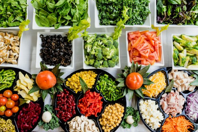 A varied table of whole foods and vegetables — photo by Dan Gold on Unsplash